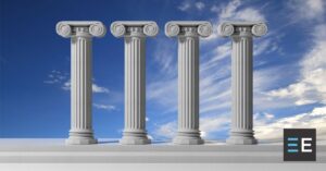 Four architectural pillars against a blue sky