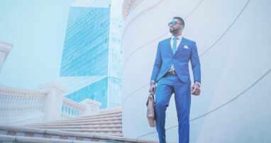 A business person with a breifcase walks down a set of outdoor stairs