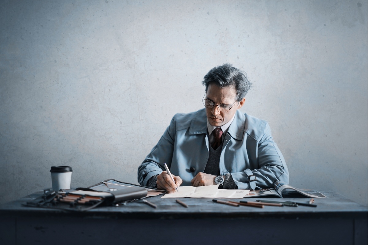 A person performs business writing at a cluttered desk