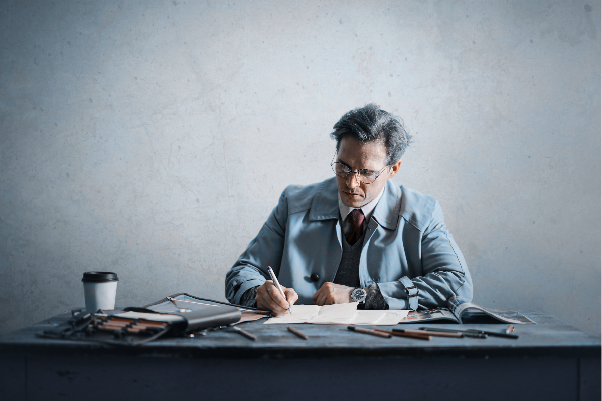 A person performs business writing at a cluttered desk