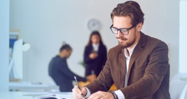 A business author takes notes in a clean, white office