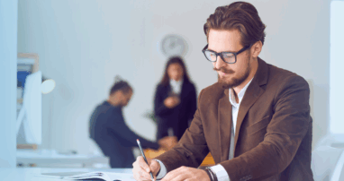 A business author takes notes in a clean, white office
