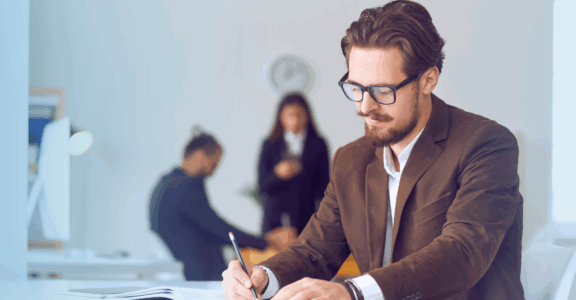 A business author takes notes in a clean, white office