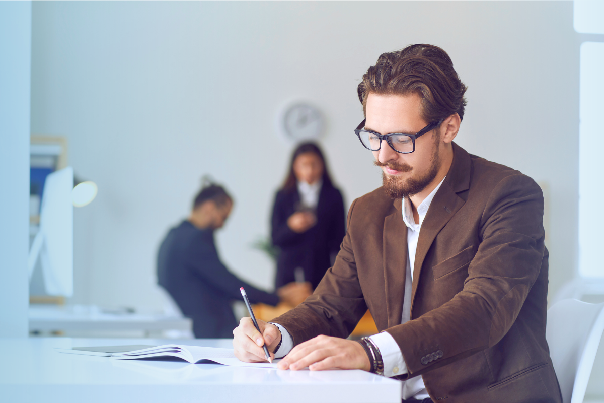 A business author takes notes in a clean, white office