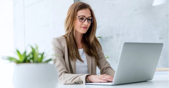 An executive types on a laptop