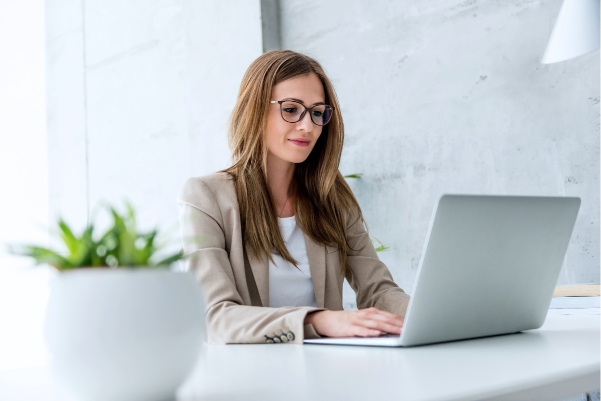 An executive types on a laptop