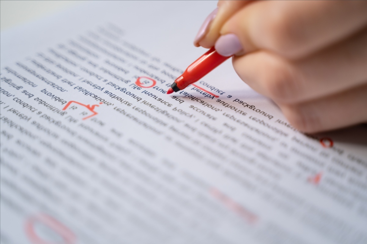 An editor marks up a manuscript with a red marker