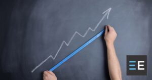 A person tape measuring a chalk drawing of an upward growth trend graph