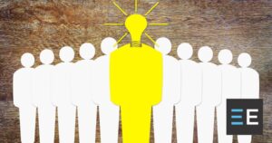 Paper cut outs of people; a yellow one with a lightbulb head is in front of the others