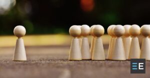 A group of abstract wooden people with one set apart