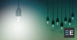 A lit light bulb set apart from seven unlit light bulbs