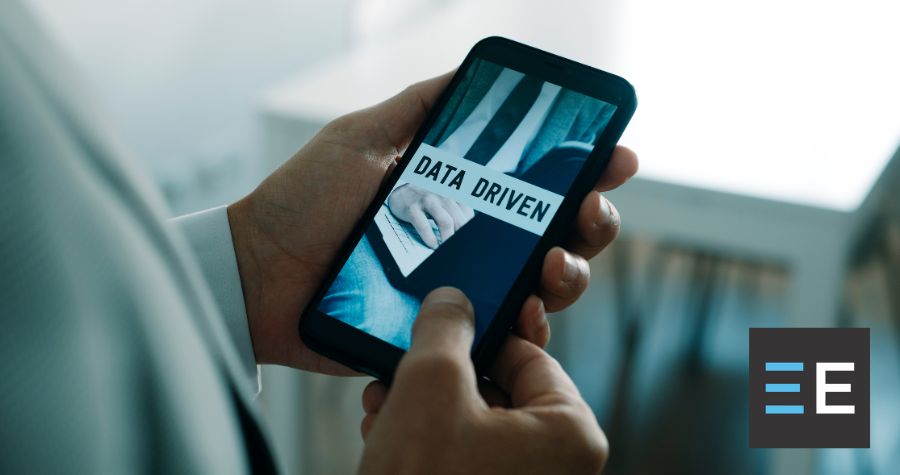 A person looking at a smartphone displaying the words "data driven"