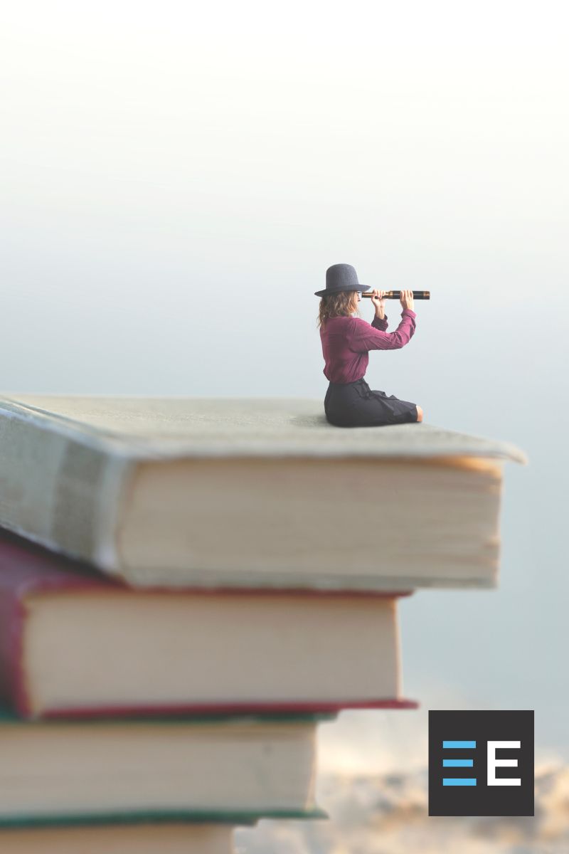 A small person looking through a spyglass seated atop a stack of books