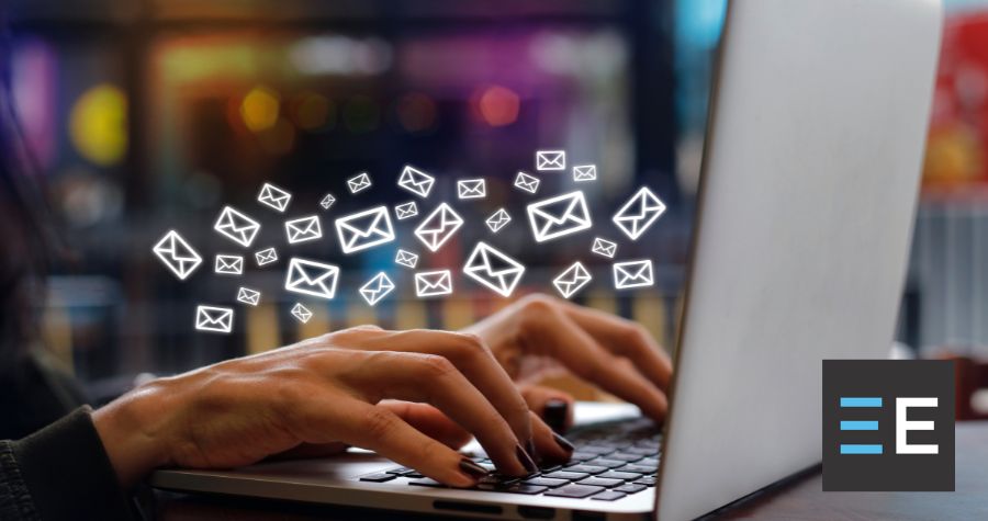 A person typing on a laptop with email icons surrounding them