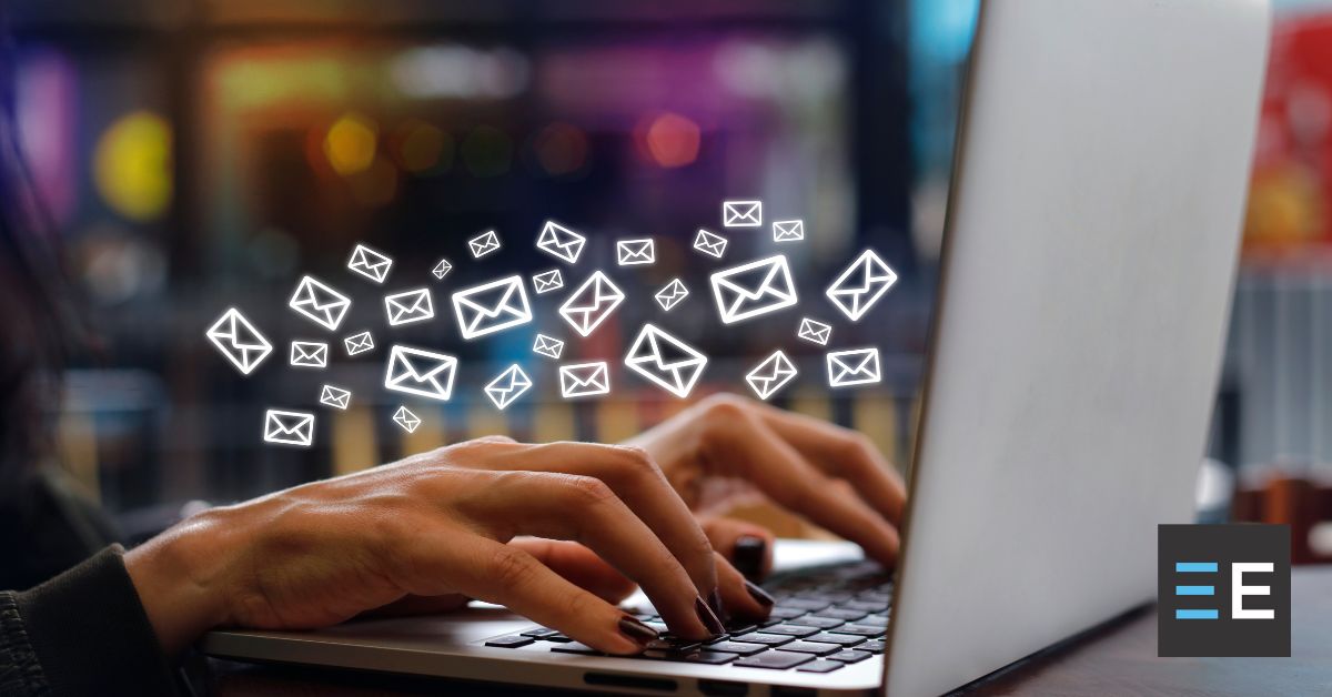 A person typing on a laptop with email icons surrounding them