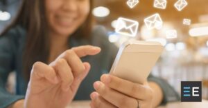 A person using their smartphone. Around it are email icons